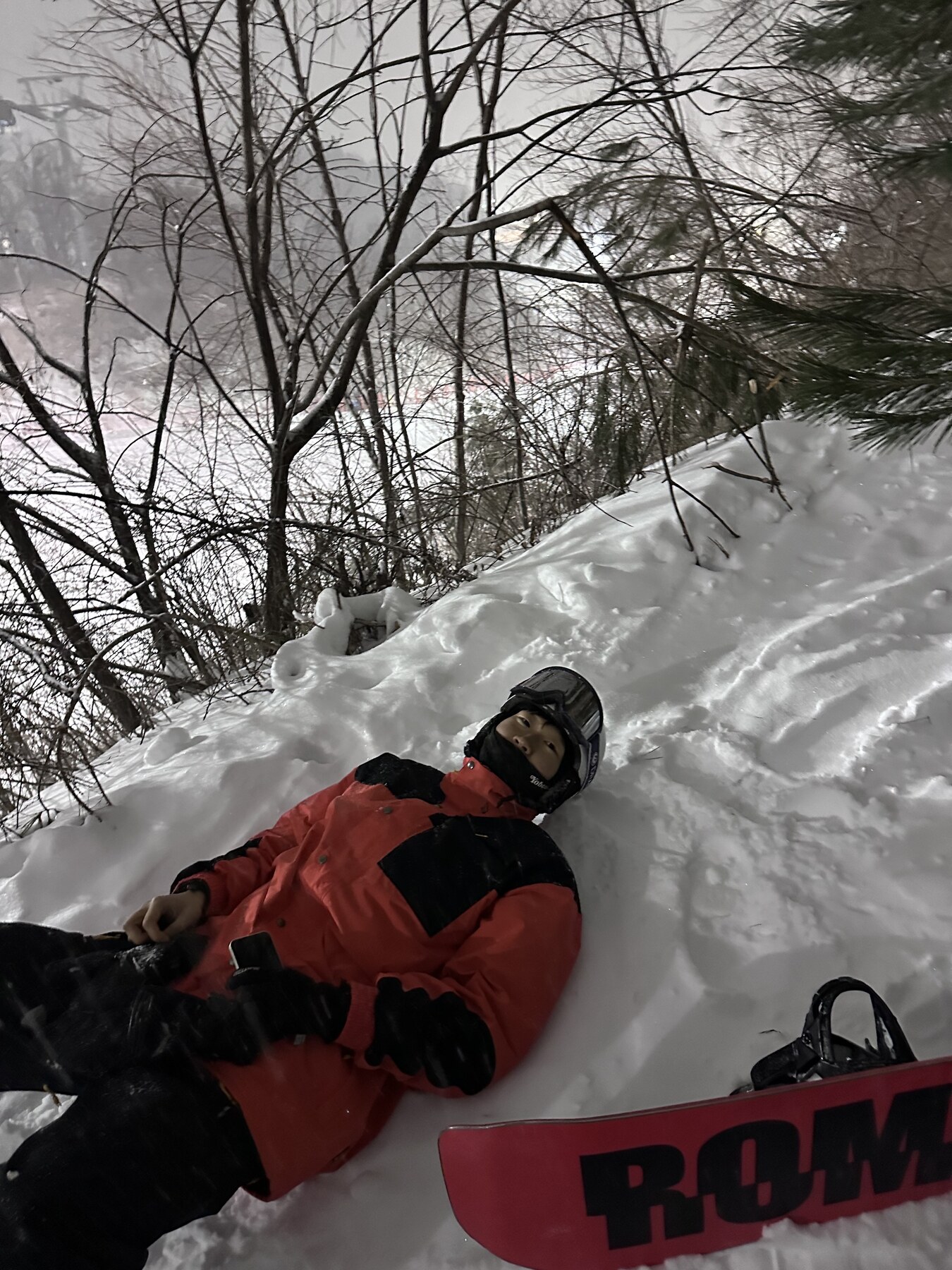 Resting in deep snow beside a snowboard